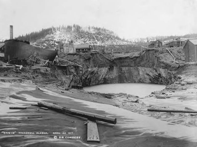The cave-in and sinkhole beside the mine buildings at the Treadwell Mine on Douglas Island, Alaska, after the workings flooded in 1917.